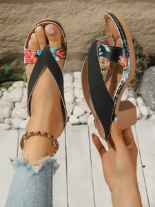 Detailed side and top view of women's black floral embroidered wedge flip-flop sandals