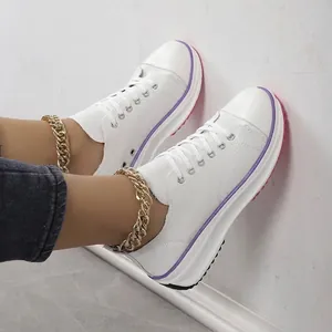 Gros plan de baskets compensées en toile blanche pour femmes avec liseré violet