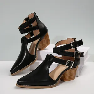 Vue détaillée de bottines noires à bout pointu avec plusieurs boucles argentées.