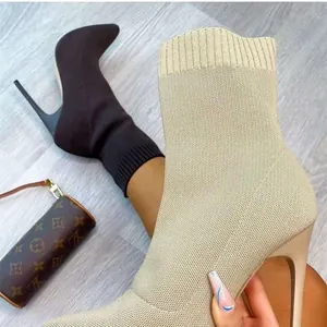 Nahaufnahme von eleganten spitzen Stiletto-Sockenstiefeln in Schwarz und Beige