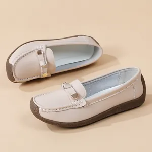 Detailed view of comfortable beige loafers featuring soft soles and metal buckle accents