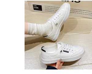 Vista dettagliata di sneaker bianche retrò con etichetta FASHION nera e suola piatta