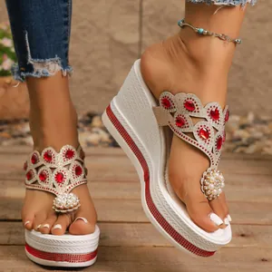 Primer plano detallado de chanclas con cuña blancas decoradas con pedrería roja