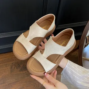 Primo piano dettagliato di eleganti sandali con zeppa beige da donna con suola marrone spessa