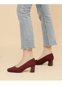 Close-up of wine red chunky heel pumps with ribbed knit texture and square toe