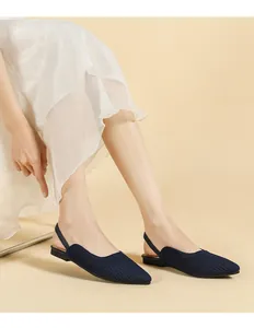 Elegant navy blue knit pointed-toe slingback flats shown on model with white dress
