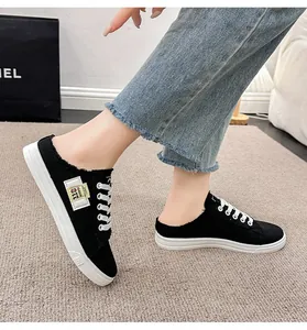 Vista detallada de modernas zapatillas mules de lona negra con cordones y suela blanca