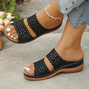 Stylische schwarze Keilsandalen mit zwei Riemen und aufwendigen Hohlblumenmustern