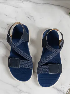 Top view of navy blue women's casual sandals featuring elastic cross-straps and Velcro fasteners