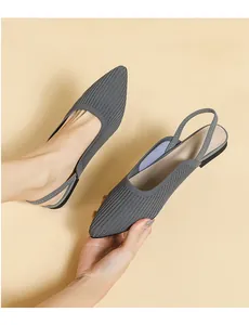 Close-up of grey knitted pointed-toe slingback flat shoes showing soft fabric texture.