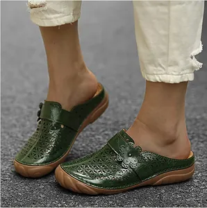 Detail view of green women's hollow-out platform mule sandals featuring floral patterns