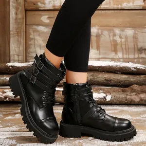 Close-up of women's black vintage motorcycle boots featuring triple buckle straps