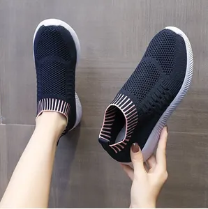 Dettaglio di scarpe da ginnastica slip-on in maglia blu scuro con bordo a righe rosa