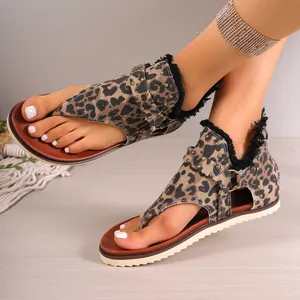 Close-up detail of leopard print thong sandals with vintage metal studs and frayed edges