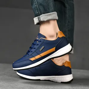 Men's stylish navy blue leather casual sneakers with tan accents and thick white soles.