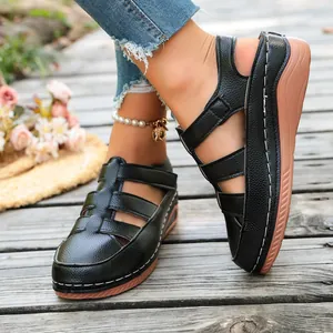 Nahaufnahme des strukturierten schwarzen Leders und der weißen Nähte an Sandalen