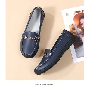 Elegant navy blue women's loafers with a decorative gold chain buckle and soft black soles