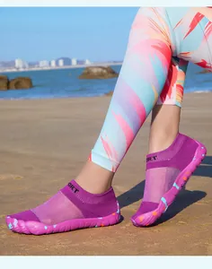 Professional purple quick-dry barefoot water shoes for outdoor sports shown on a sandy beach