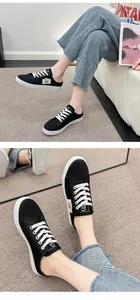 Primer plano de zapatillas tipo mule de lona negra para mujer con cordones blancos