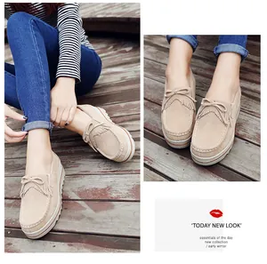 Detalle de mocasines con plataforma de ante beige con flecos y lazo decorativo