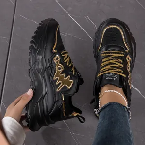Detailed view of black and gold fishbone chunky sneakers with breathable mesh materials