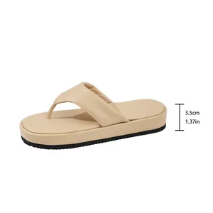 Detalle de la altura del tacón de plataforma de 3,5 cm de la sandalia de dedo beige.