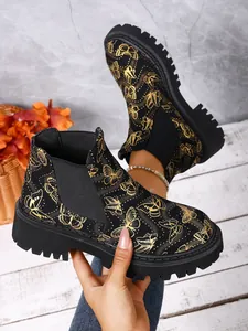 Detalle de los botines Chelsea para mujer con estampado de mariposas y suela de track gruesa
