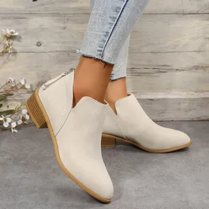 Stylish cream pointed toe ankle boots with a chunky wooden heel shown worn on feet