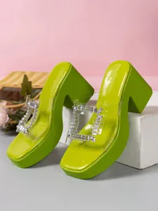 Side view of lime green platform heeled slippers with clear rhinestone buckle detail
