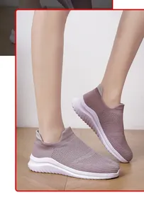 Close-up detail view of lightweight mauve knit sock sneakers worn by model on wooden floor