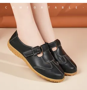 Detailansicht retro schwarzer flacher Lederschuhe mit Schnallenriemen am Modell