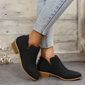 Fashionable black pointed-toe Chelsea ankle boots for women shown on a model in a rustic setting