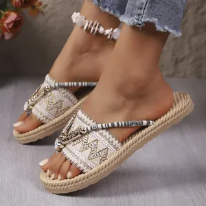 Detalle de sandalias boho con plataforma, bordados dorados y suela gruesa trenzada.