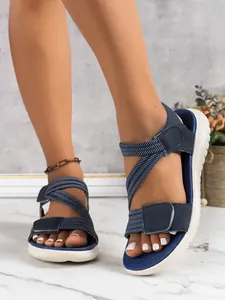 Close-up of blue casual wedge sandals with elastic straps and comfortable white sole.