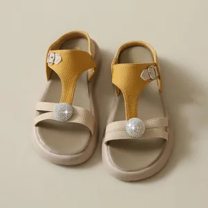 Draufsicht auf elegante gelbe und beige Plateausandalen mit funkelnden Strasskugeln