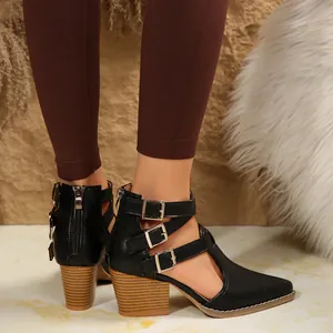Vue détaillée de sandales noires à talons épais avec bout pointu et boucles décoratives.