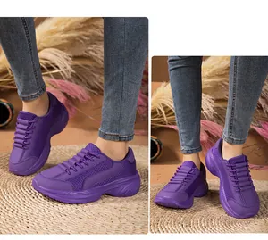 Close-up of purple breathable mesh sneakers with thick soles worn by a model on a mat