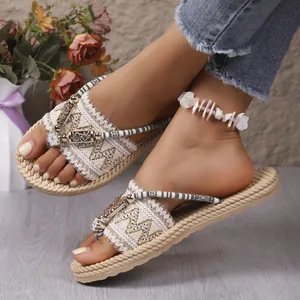 Vista detallada de las chanclas con cuña de paja llevadas para vacaciones de playa