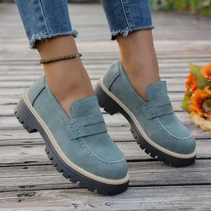 Gros plan de mocassins en nubuck bleu vintage avec semelle plateforme sur plancher en bois