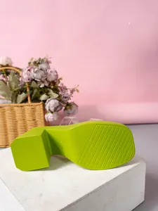 Bottom view of lime green platform slipper showing non-slip sole texture and chunky heel