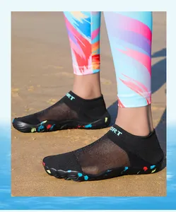 Detailed view of breathable black mesh aqua shoes for swimming on a sandy beach