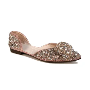 Zijaanzicht van een elegante oudroze platte schoen bedekt met parels en strass-steentjes