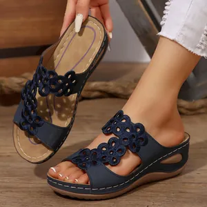 Dettaglio di sandali con zeppa blu navy con decorazione in ricamo floreale traforato