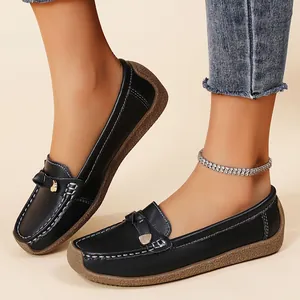 Close-up of black leather loafers with soft soles and decorative bow detailing for women.