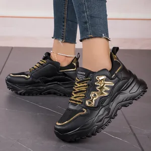 Detail of black and gold chunky sneakers with breathable mesh on a model.