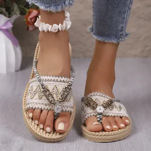 Detalle de chanclas de cuña tejidas en paja con detalles florales y suela gruesa