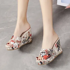Floral print wedge mule sandals for women with peep toe on marble background.