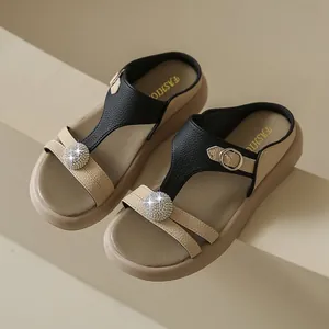 Detailansicht modischer Damen-Plateausandalen mit Strasskugel und Lederstruktur