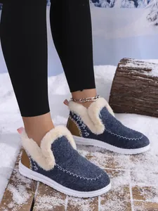 Warm women's blue fur-lined winter moccasins shown in a cozy outdoor snow setting