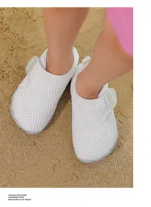 Close-up detail of white breathable mesh baby beach shoes worn by a child on sand